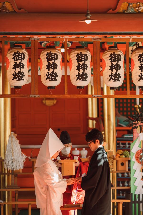 道後うめ乃やでご結婚式を挙げられたお客様の写真　指輪交換をしている紋付袴白無垢姿の新郎新婦様