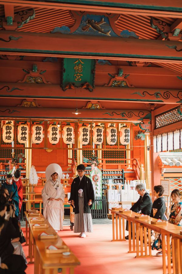 道後うめ乃やでご結婚式を挙げられたお客様の写真　ご家族様に見守られ神前式退場をしている紋付袴白無垢姿の新郎新婦様