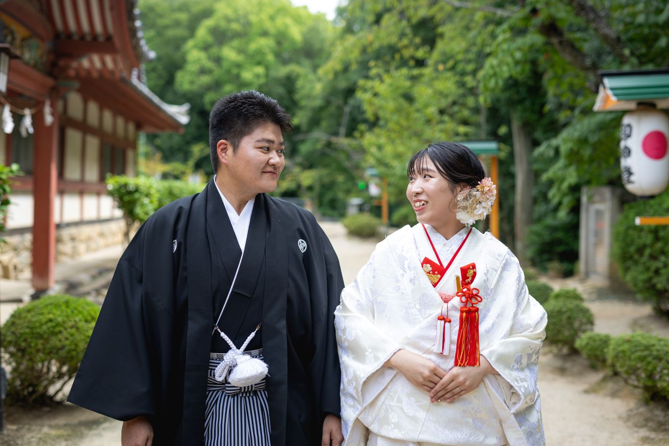伊佐爾波神社で挙げられたお客様の結婚式写真　駐車場から境内へ移動をする紋付袴白無垢姿の新郎新婦様