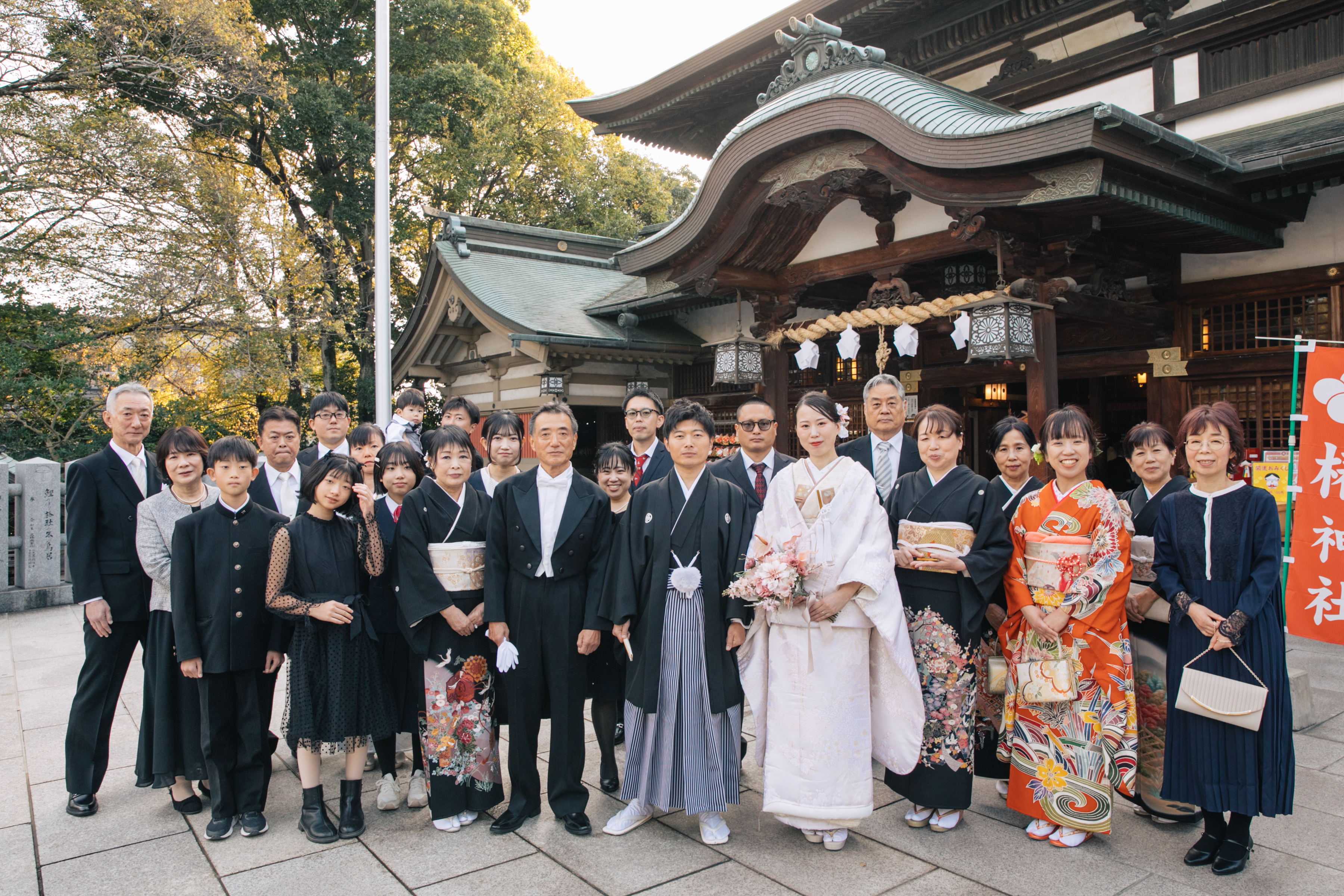 伊豫豆比古命神社 椿祷殿（椿神社）で挙げられたお客様の結婚式　神社の前で家族写真を撮る紋付袴白無垢姿の新郎新婦様