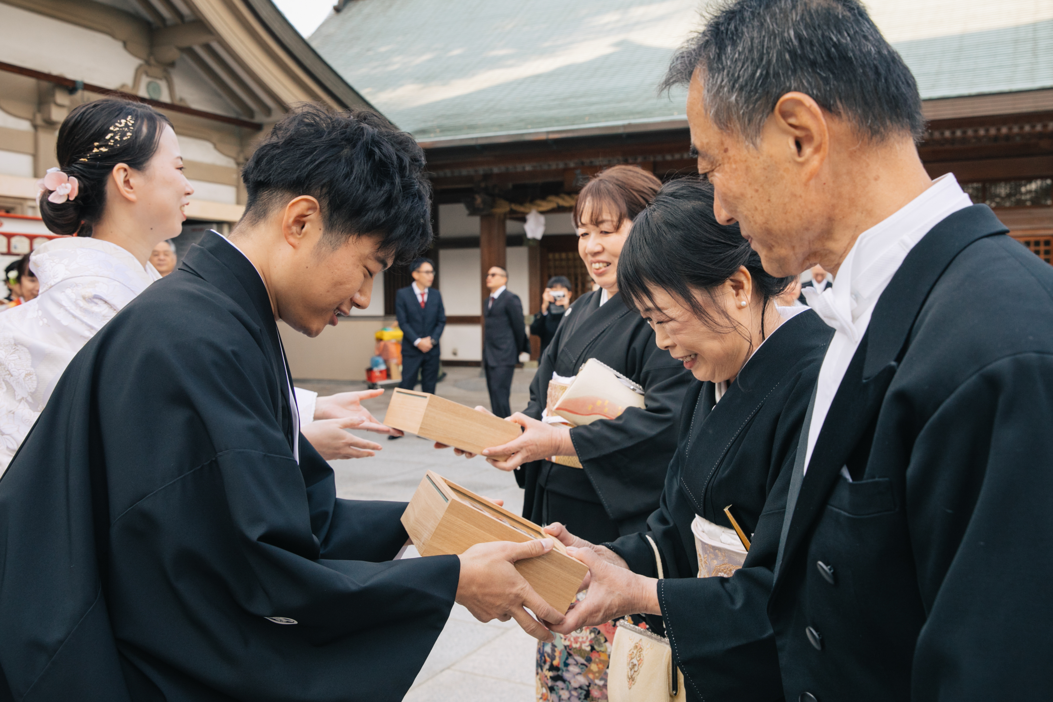 伊豫豆比古命神社 椿祷殿（椿神社）で挙げられたお客様の結婚式　ご両親様へお花の記念品をお渡しする紋付袴白無垢姿の新郎新婦様