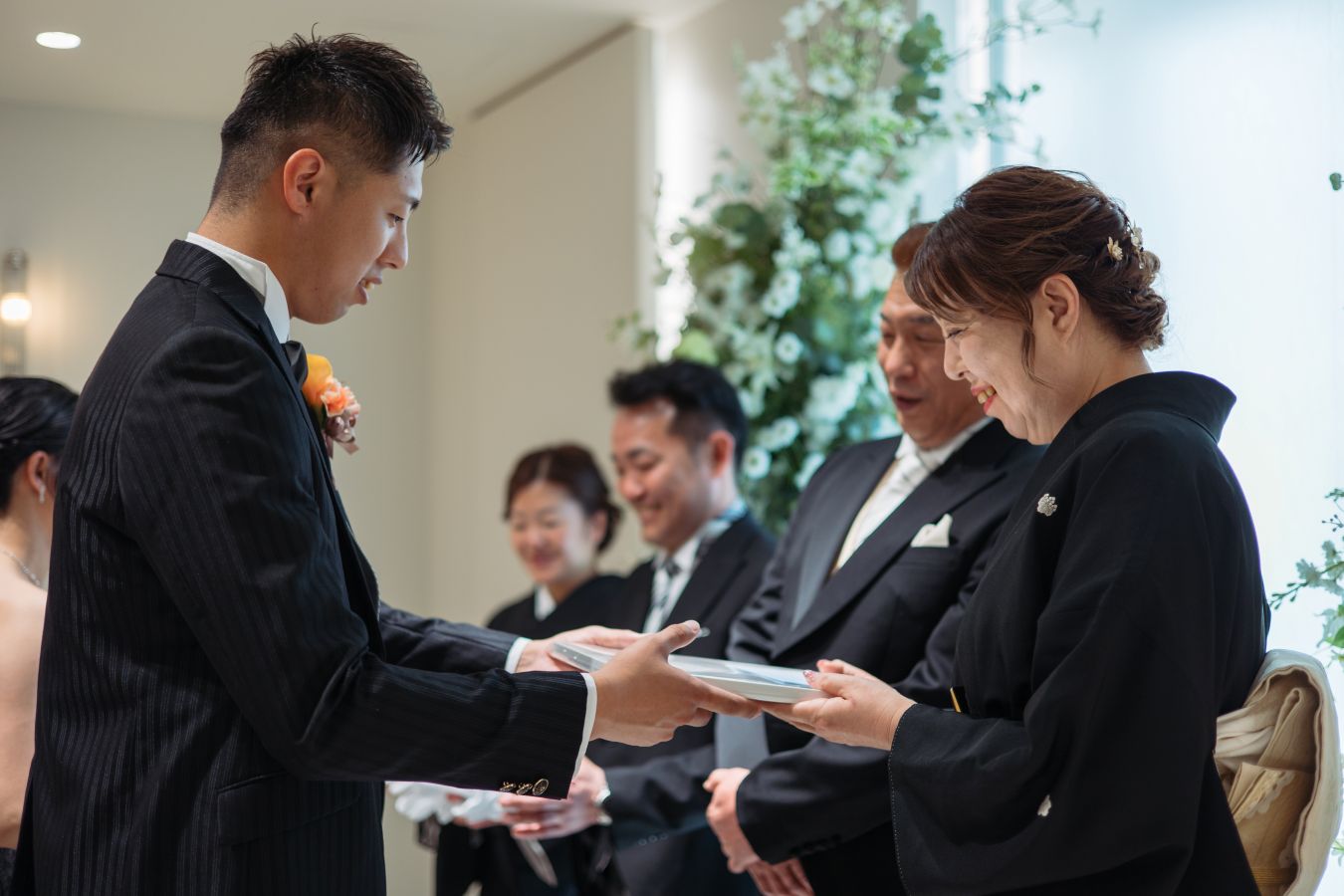 小さな結婚式 松山チャペルで挙げられたお客様の結婚式写真　再入場をしてご両親様に記念品を贈呈する新郎様