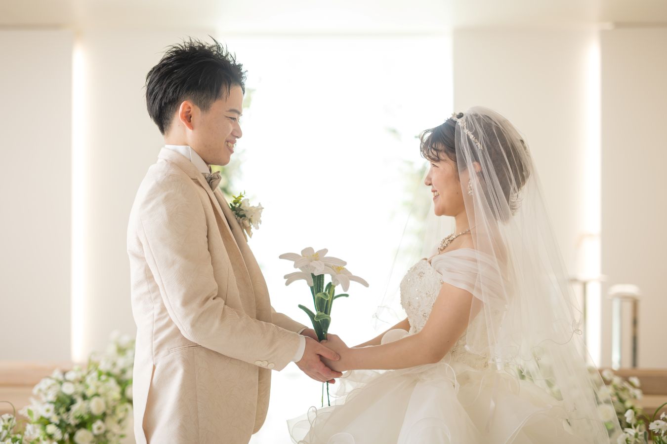 小さな結婚式 松山チャペルで挙げられたお客様の結婚式写真　新郎新婦様のツーショット　いただいたお花を持って見つめあいます