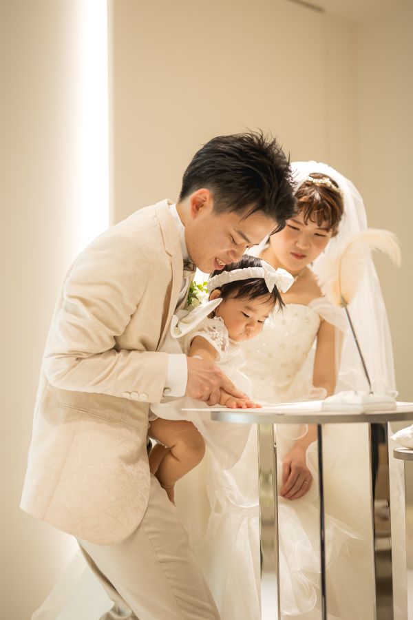 小さな結婚式 松山チャペルで挙げられたお客様の結婚式写真　新郎新婦様の結婚誓約書に手形を押すお子様
