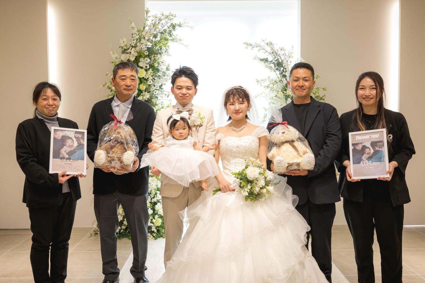 小さな結婚式 松山チャペルで挙げられたお客様の結婚式写真　記念品を持ってお写真を撮る新郎新婦様とご両親様