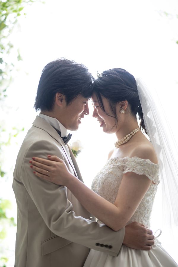松山スタジオで撮影された新郎新婦様のお写真　少し照れながら見つめあう新郎新婦様