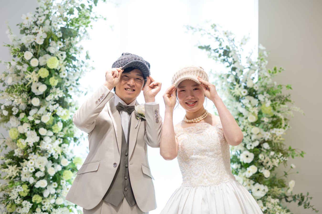 松山スタジオで撮影された新郎新婦様のお写真　色違いでおそろいの帽子をつける新郎新婦様