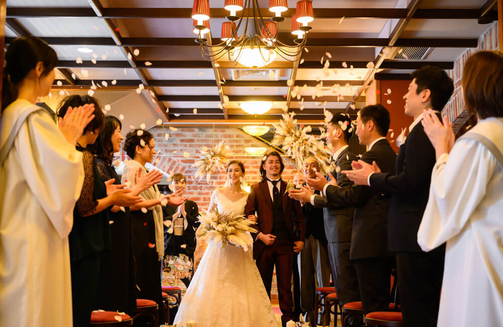 100年のハレを見守り続けた歴史と伝統が息づくロビーで執り行うチャペル式  モダンな空間にはお洒落なシャンデリアと温かなレンガ壁がおふたりを演出  親御様のエスコートで歩むバージンロードは感謝を感じる結婚式です