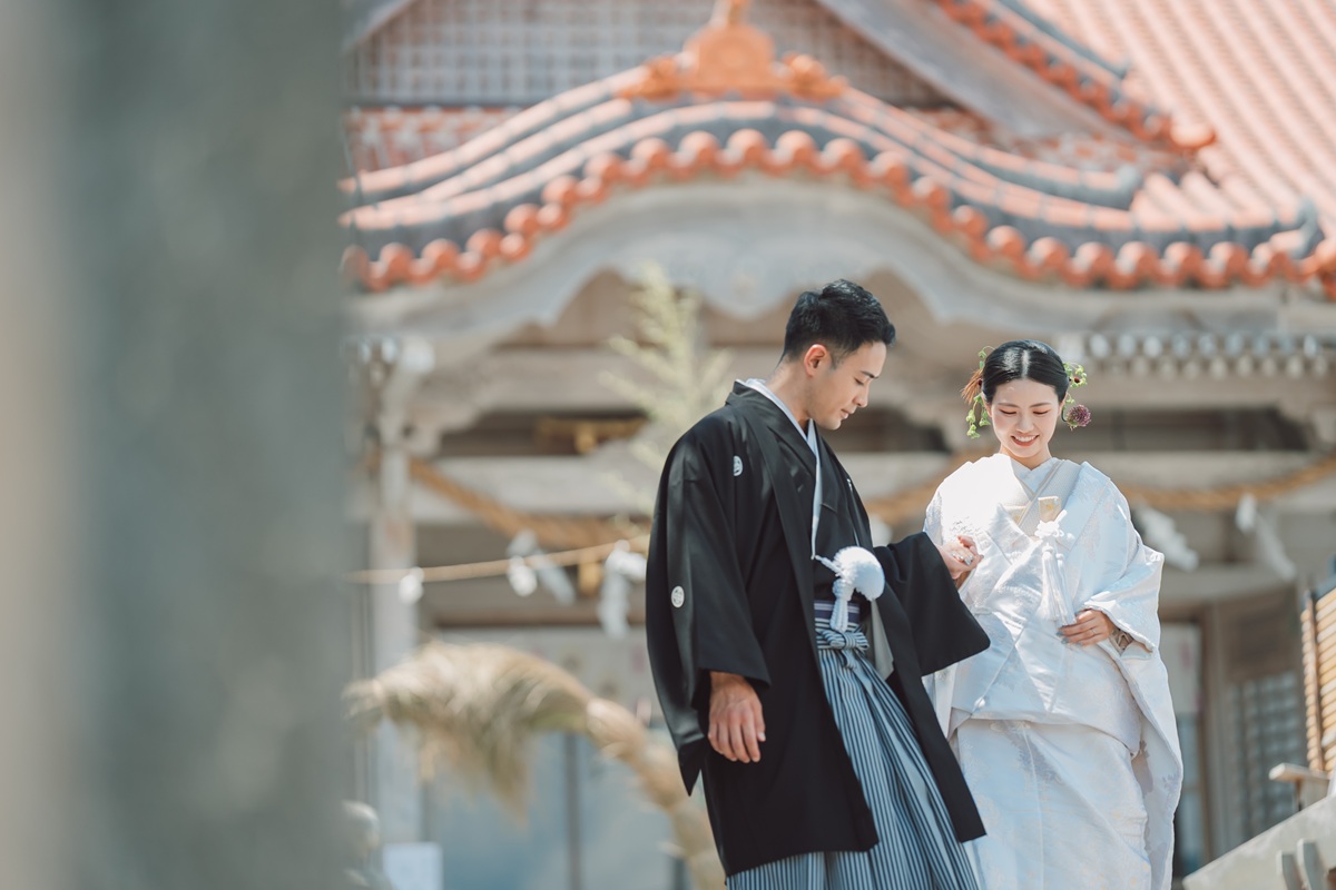 神社を背景に写真を撮る二人